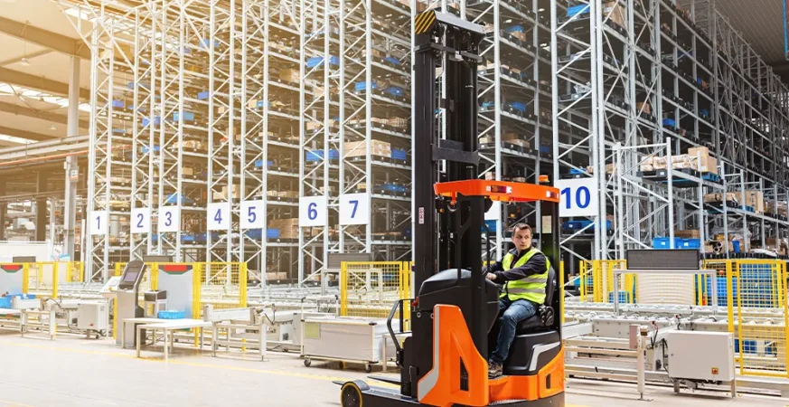 Empilhadeira elétrica operando em centro de distribuição logístico, representando o uso de bateria de lítio ou chumbo-ácido em operações industriais. Crédito: Алина Бузунова – Adobe Stock.