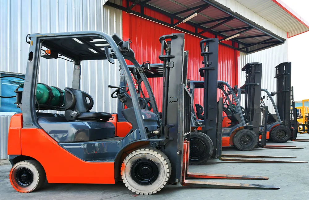 Empilhadeiras usadas estacionadas em pátio industrial, prontas para operação.