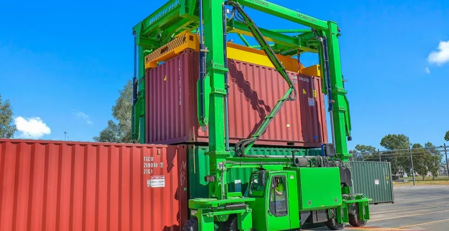 Manipulador de contêineres com emissão zero da Mobicon Systems operando em ambiente portuário, destacando inovação em logística sustentável.