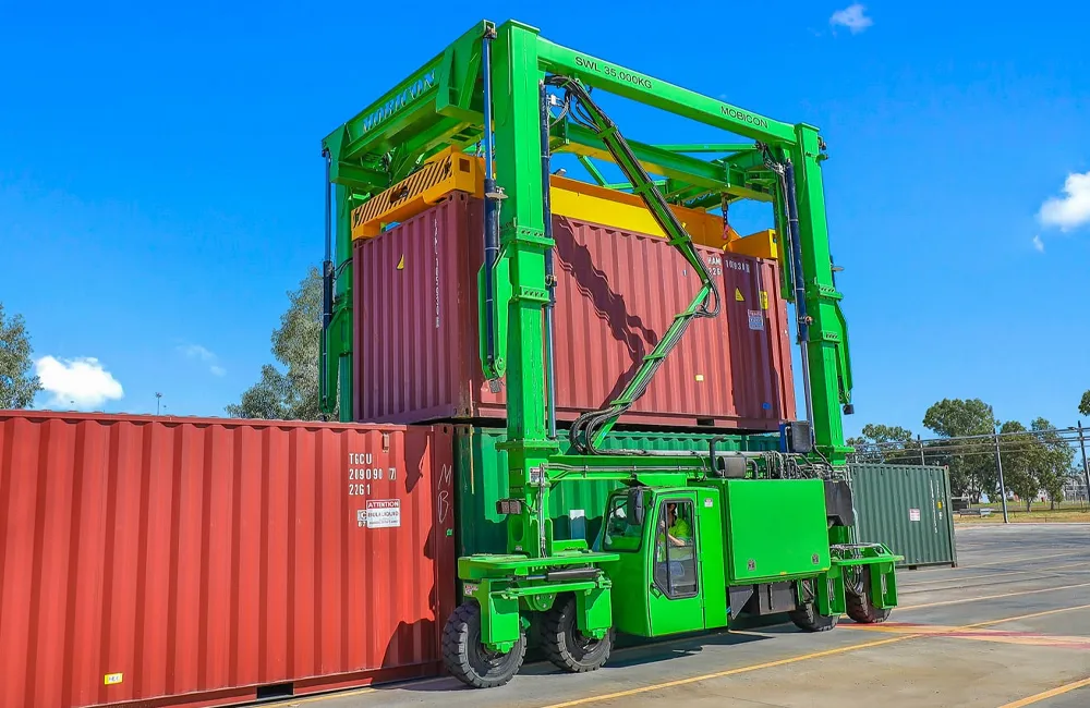 Manipulador de contêineres com emissão zero da Mobicon Systems operando em ambiente portuário, destacando inovação em logística sustentável.
