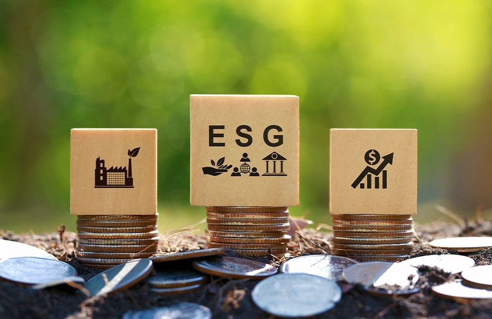 Blocos com ícones de ESG sobre pilhas de moedas representando sustentabilidade e desempenho financeiro.