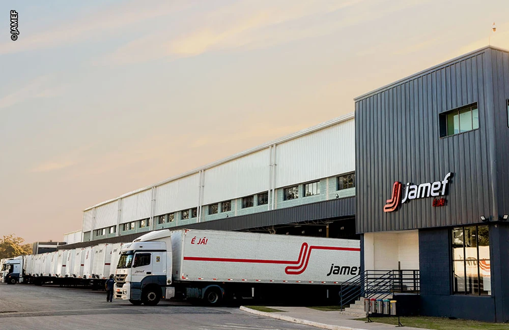 Caminhão trafegando em rodovia paulista ao entardecer, com destaque para o eixo traseiro e lanterna acesa.