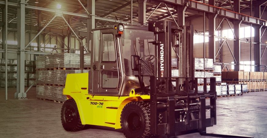 Empilhadeira Hyundai 70D-7E ACE operando dentro de armazém, projetada para movimentação pesada.