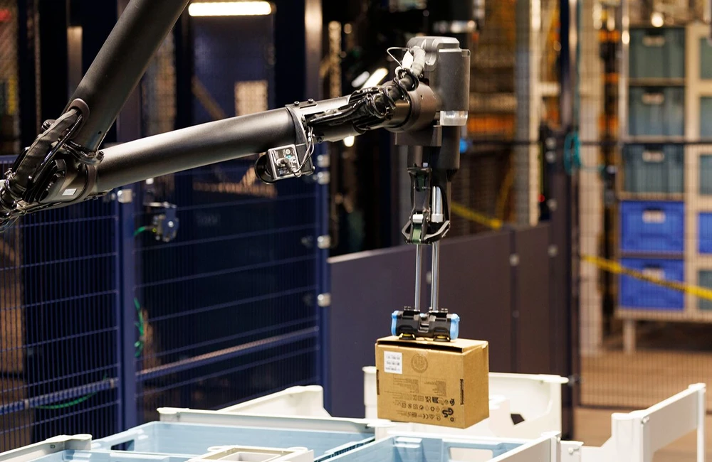 Braço robótico industrial manipulando uma caixa em ambiente automatizado de armazém.
