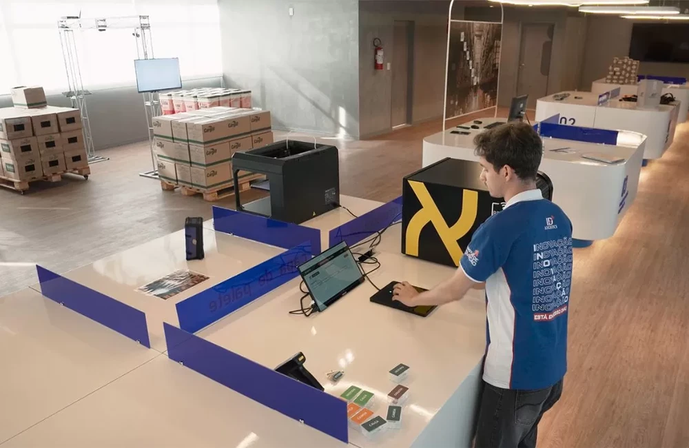 Profissional utilizando solução digital em estação de testes dentro de um ambiente de inovação logística.