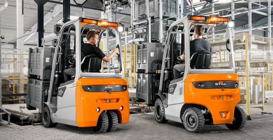 Empilhadeiras contrabalançadas operando em ambiente industrial com racks e paletes, ilustrando seu papel na movimentação de cargas.