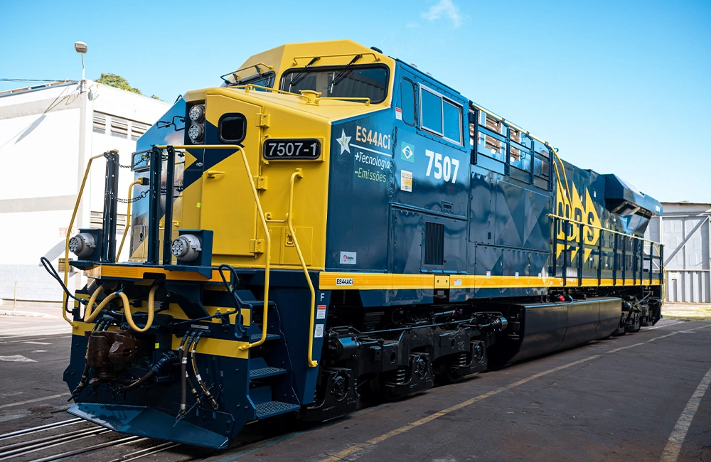 Locomotiva ES44ACi da MRS Logística estacionada em terminal ferroviário, destacando tecnologia de baixa emissão e modernização do transporte ferroviário no Brasil.