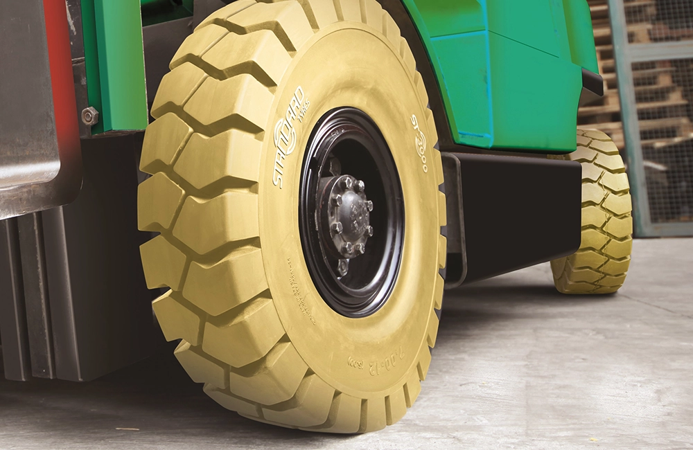 Pneu sólido industrial para empilhadeira Hyundai, com banda de rodagem larga, ideal para piso interno em operações logísticas no Brasil.
