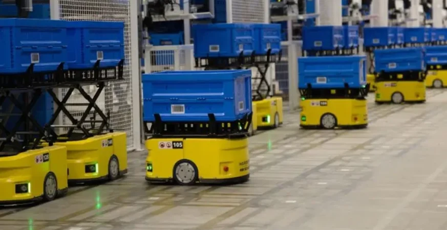 Robôs móveis autônomos transportando caixas em centro de distribuição automatizado, ilustrando operações de intralogística avançada.