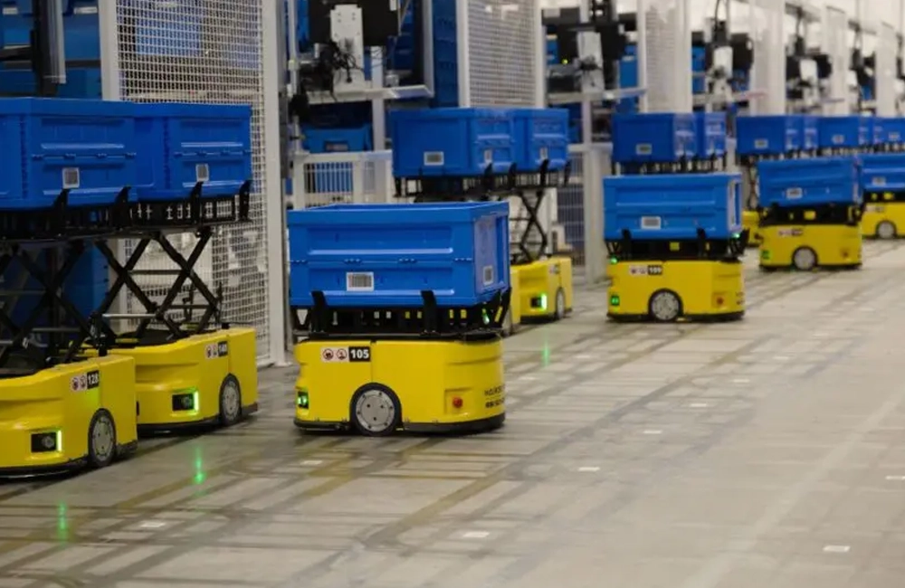 Robôs móveis autônomos transportando caixas em centro de distribuição automatizado, ilustrando operações de intralogística avançada.