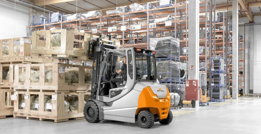 Empilhadeira elétrica operando em centro de distribuição, ilustrando o impacto da temperatura na vida útil das baterias industriais.