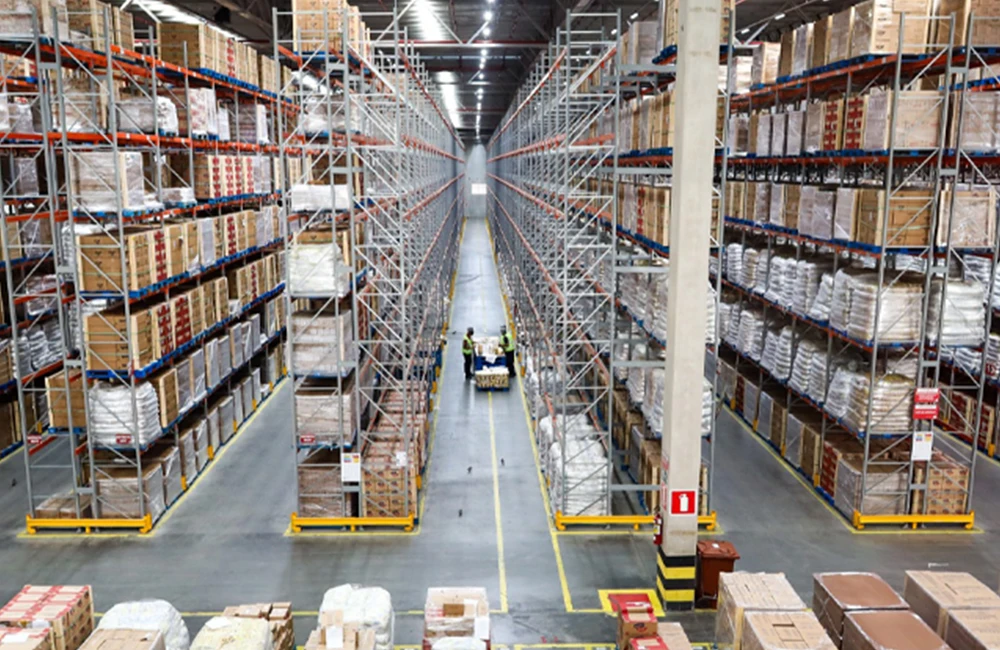 Operação logística em armazém da JSL com empilhadeiras e estoques abastecidos, ilustrando a preparação para a alta de 40% na demanda de Natal.