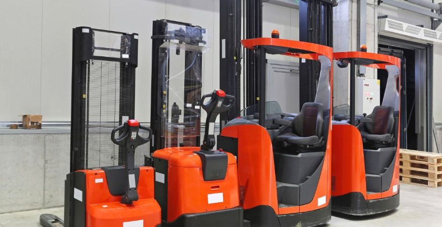 Grupo de empilhadeiras elétricas novas e vermelhas em um armazém, prontas para uso. Ilustração do artigo sobre a decisão de alugar ou comprar empilhadeiras.