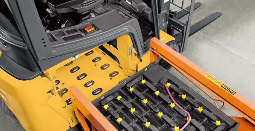 Close-up de uma bateria de empilhadeira sendo verificada com um multímetro ou equipamento de teste, indicando a perda de força.