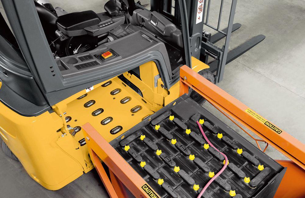 Close-up de uma bateria de empilhadeira sendo verificada com um multímetro ou equipamento de teste, indicando a perda de força.