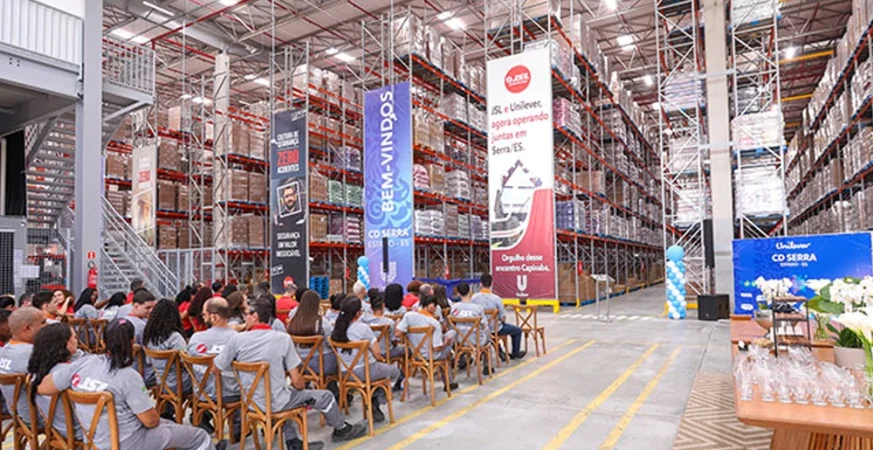 vento de inauguração do novo centro de distribuição da Unilever no Espírito Santo, mostrando a estrutura de armazenagem e convidados.